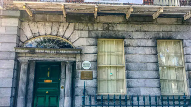 Front entrance of The People&rsquo;s Museum of Limerick, featuring a green door, two large windows, and a banner above the doorway.